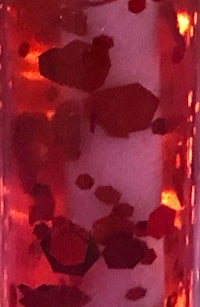 a close up of a bottle with red liquid in it